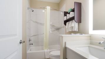 A bathroom with a bathtub, toilet, and sink.