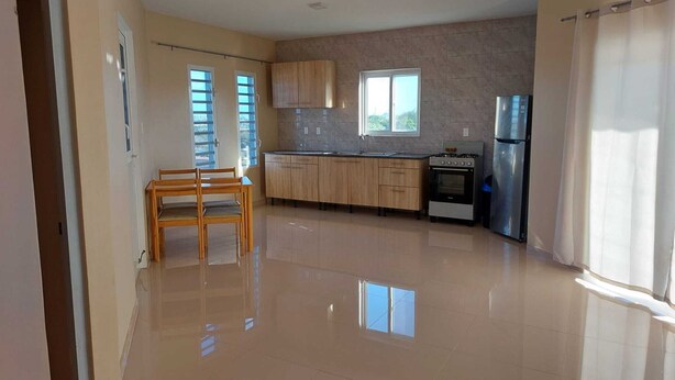 A spacious kitchen with wooden cabinets, a dining table, and a built-in oven.