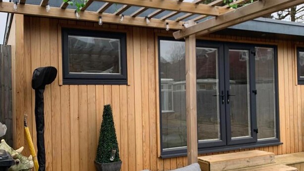 A wooden exterior with a pergola, a small potted plant, and a grey sofa. - Lodge , air con , Free Parking , Mini bar (Hove)