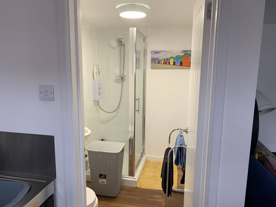 A modern bathroom with a glass-enclosed shower, a toilet, and a sink.