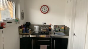 A compact kitchen with a stainless steel countertop, a kettle, a toaster, and a sink. - Lodge , air con , Free Parking , Mini bar (Hove)