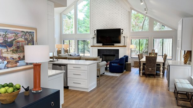 A spacious kitchen with a central island, a dining area with wicker chairs, and a living room with a fireplace. - 9 Sandhill Crane at Sea Pines Resort (Hilton Head Island)