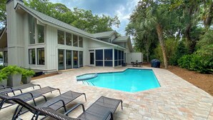 A modern house with a large swimming pool, outdoor seating, and a covered patio area. - 9 Sandhill Crane at Sea Pines Resort (Hilton Head Island)