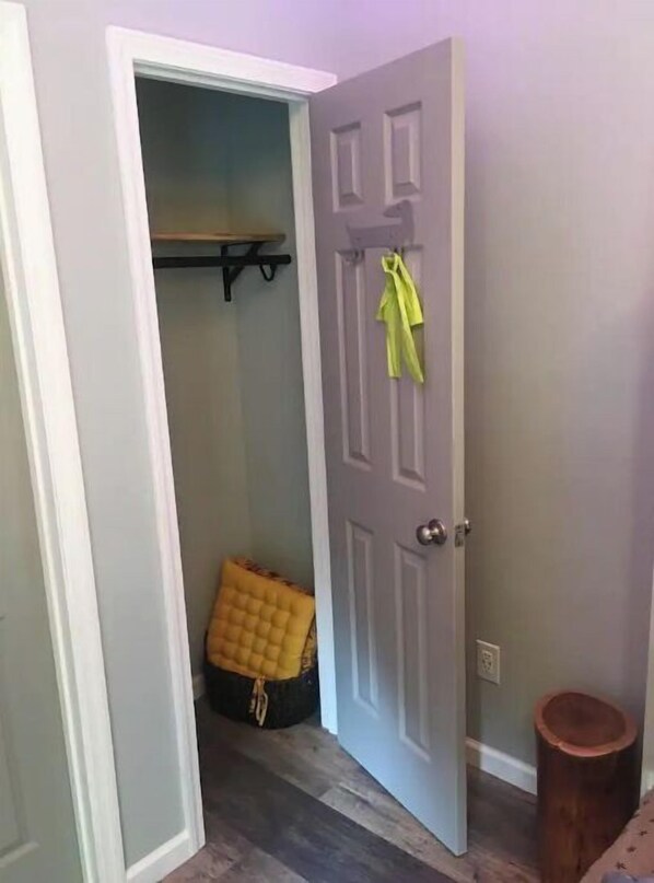 Enter a cozy space with a door leading to a room, featuring a wooden floor and a bench for resting.