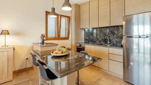 Una cocina moderna con encimera de mármol, electrodomésticos de acero inoxidable y armarios de madera.