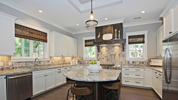 A modern kitchen with white cabinetry, a granite countertop, and a stainless steel refrigerator. - 12 Green Heron at The Sea Pines Resort (Hilton Head Island)