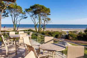 Une terrasse avec mobilier d’extérieur donnant sur la plage.