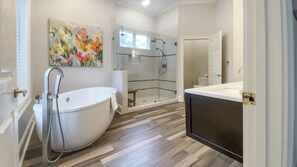 Ein modernes Badezimmer mit einer freistehenden Badewanne, einer Duschkabine und einem großen Spiegel.