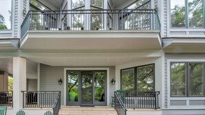 Ein zweistöckiges Gebäude mit Balkon, großen Fenstern und einem überdachten Eingang.