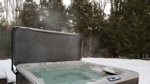 Un jacuzzi con banco en un paisaje nevado.