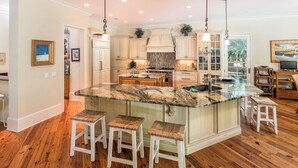 A spacious kitchen with a large island, wooden flooring, and pendant lighting. - 34 Baynard Cove Rd. at The Sea Pines Resort (Hilton Head Island)
