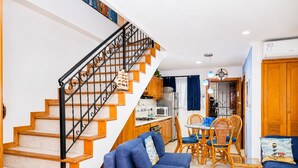 A living room with a staircase, a dining area, and a kitchen. - The best apartment - sea views (Santa Marta)