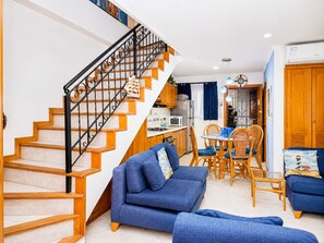 Ein Wohnzimmer mit Treppe, Essbereich und Küche.