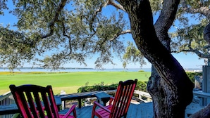 Una terraza con dos mecedoras que da a un campo de golf.