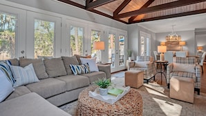 A spacious living room with a large sectional sofa, two armchairs, a coffee table, and a dining area with a chandelier. - 43 Stoney Creek at The Sea Pines Resort (Hilton Head Island)