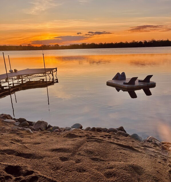 A serene lakeside scene with a dock and a paddle boat. - Lake Escape | paddle boards, fire pit & game room (Lake Park)
