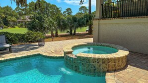 A swimming pool with a hot tub, surrounded by a brick patio and lush greenery. - 147 N. Sea Pines Dr. at The Sea Pines Resort (Hilton Head Island)