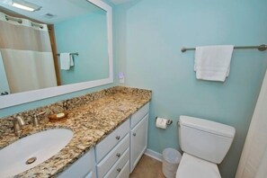 A bathroom with a granite countertop sink, a white toilet, a towel rack, and a mirror. - 282 Stoney Creek Villa at The Sea Pines Resort (Hilton Head Island)