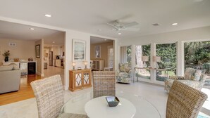 A spacious living area with a glass coffee table, wicker chairs, and a view of the outdoors. - 337 Greenwood Dr. at The Sea Pines Resort (Hilton Head Island)