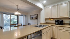 A modern kitchen with a large island, stainless steel appliances, and beige cabinetry. - 540 Plantation Club Villas at The Sea Pines Resort (Hilton Head Island)