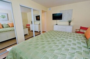 Una habitación de hotel con cama, televisión, escritorio y una silla.