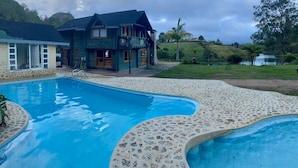 A pool area with a house in the background.