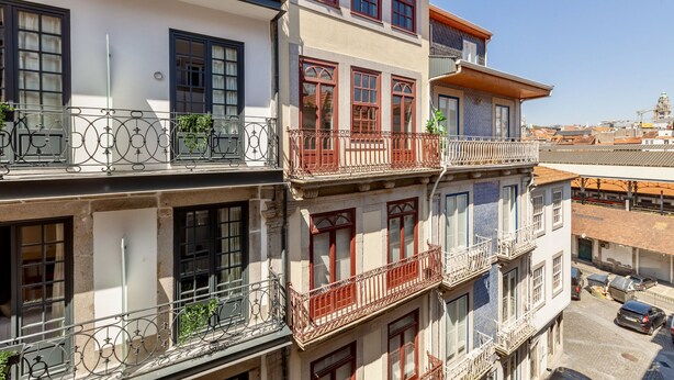 Un edificio de varios pisos con balcones, ventanas amplias y una vista despejada del entorno.
