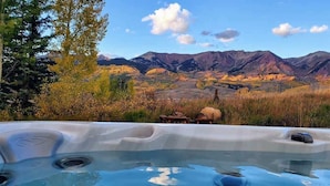 A hot tub with a mountainous landscape in the background. - Goldlink Lodge (Crested Butte)