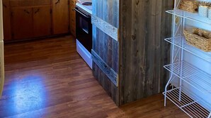 Une cuisine avec des meubles de rangement en bois, un évier et une pancarte sur laquelle on peut lire : « BISCUITS FAITS MAISON ».