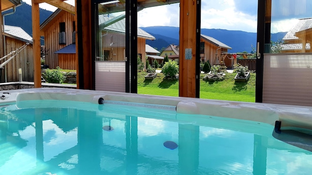 Ein Whirlpool mit Blick auf Holzhütten und Berge.