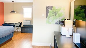 A modern hotel room with a bed, desk, chair, and a large window. - Parlee Beach Motel (Shediac)