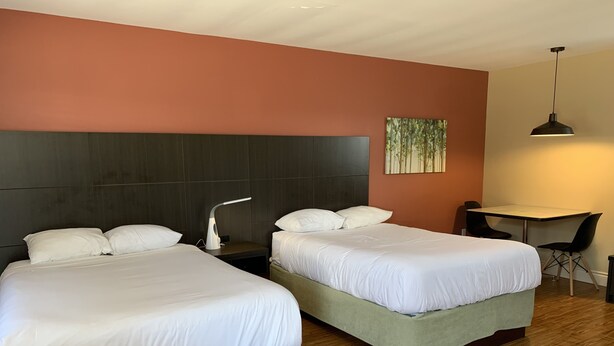 A hotel room with two beds, a desk, and a chair. - Parlee Beach Motel (Shediac)