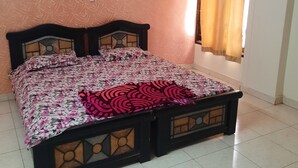 Une chambre à coucher avec un lit, des murs à motifs, un appareil de climatisation et une fenêtre avec des rideaux.