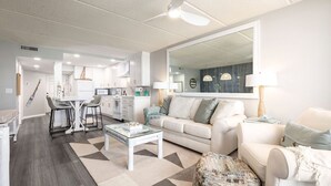 Ein modernes Wohnzimmer mit Sofa, Couchtisch und einem Essbereich mit Stühlen und Tisch.