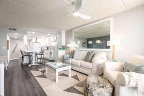 Ein modernes Wohnzimmer mit Sofa, Couchtisch und einem Essbereich mit Stühlen und Tisch.
