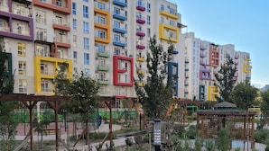 A multi-story residential building with balconies, a playground, and a garden area. - Luxury Apartment in Tbilisi | 24/7 Security | Prime Location (T'bilisi)