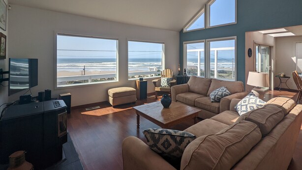 A spacious living room with large windows, a fireplace, and a view of the beach. - Poseidon's Paradise  with spectacular views. (Florence)