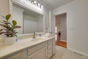 A bathroom with a large mirror, white sink, and multiple drawers. There is a potted plant and a bottle of hand soap on the counter. - Cadiz Abode w/ Decks, Fire Pit, & Lake Access (Cadiz)