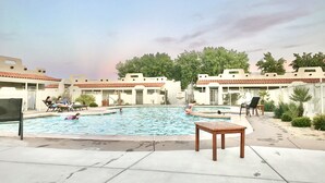 A swimming pool area with lounge chairs and a wooden table. - 34- Amira Resort Condo, Heated Pool, Hot tub, Gym (St. George)