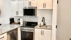 A compact kitchen with white cabinets, a stainless steel stove, a microwave, and a dishwasher. - 34- Amira Resort Condo, Heated Pool, Hot tub, Gym (St. George)