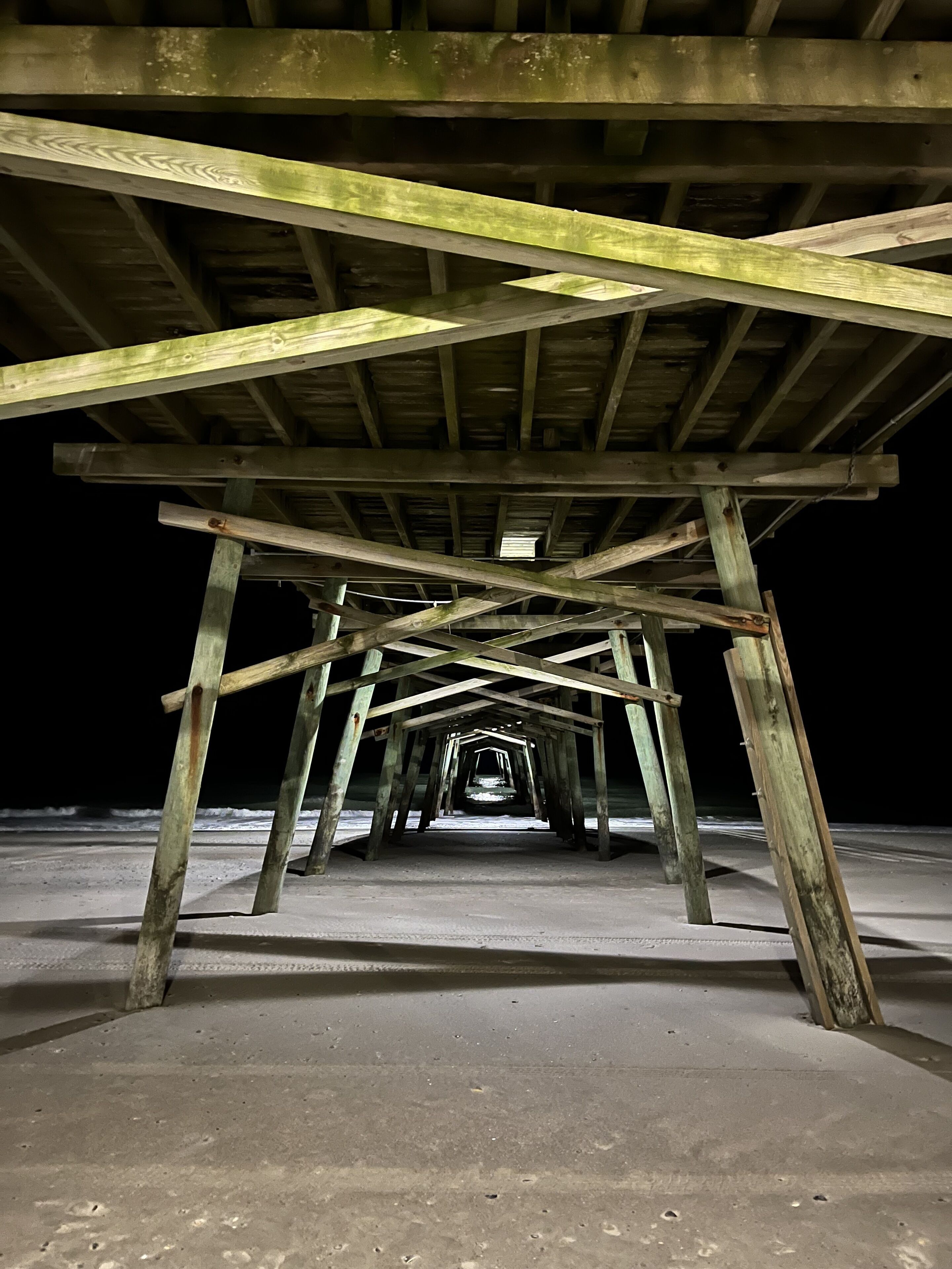 A wooden structure with a concrete floor, likely a pier or dock extending into a body of water.