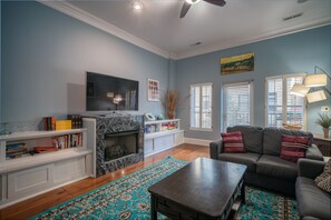 A living room with a fireplace, a flat-screen TV, a sofa, and a coffee table.