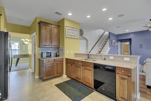 A kitchen with wooden cabinets, a dishwasher, and a granite countertop.