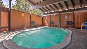 A covered outdoor swimming pool with a wooden fence, a ladder, and a few chairs. - Mammoth Lakes Townhome < 2 Mi to Ski Area! (Mammoth Lakes)