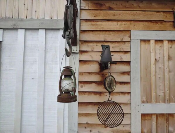 A wooden wall with a white door and two wall-mounted lanterns.
