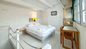 Una habitación de hotel con cama, mesita de noche y un pequeño escritorio con silla.