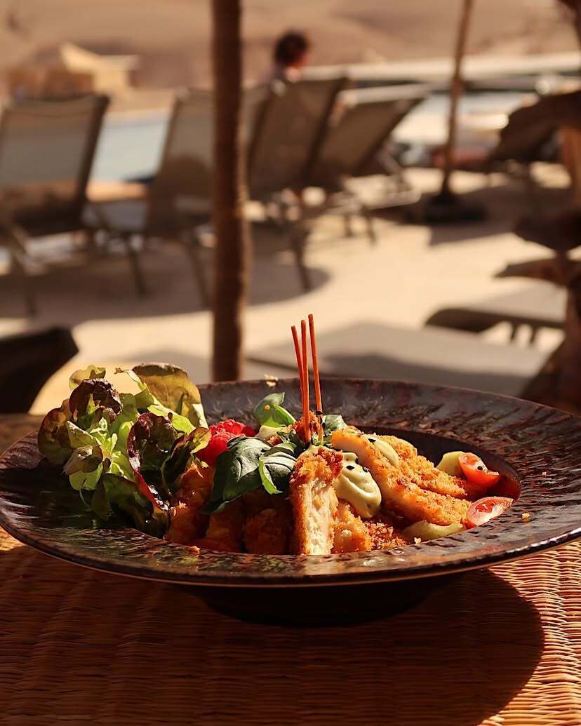 A plate of food with a salad and bread on a table.