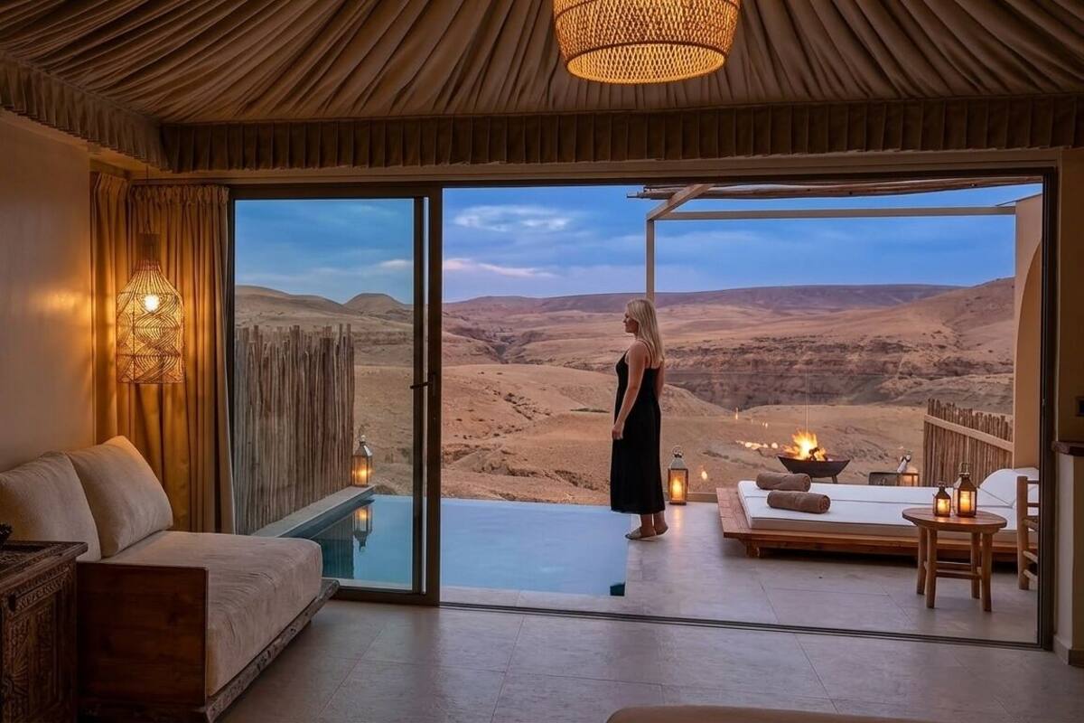 A room with a large sliding glass door, a sofa, a small table, and a fire pit.