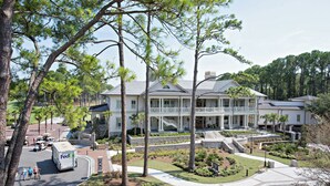 A large, two-story building with a covered porch and a landscaped front yard.