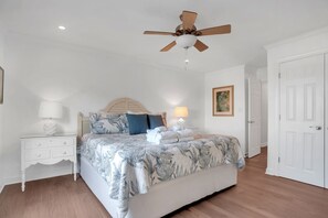 A bedroom with a bed, nightstand, ceiling fan, and a door. - 947 Cutter Court at The Sea Pines Resort (Hilton Head Island)